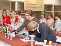 Eine Gruppe von SchülerInnen arbeitet gemeinsam in einem naturwissenschaftlichen Labor an einem Experiment.