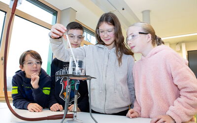 Vier Schüler experimentieren neugierig im Biologie, Naturphänomene und Technik Unterricht