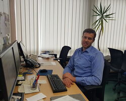 Peter Schuldt sitzt am Schreibtisch und bereitet die Stundenpläne vor.