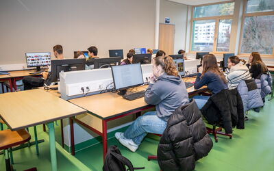 Schüler nutzen Computer im Klassenzimmer für den Basiskurs Medienbildung.