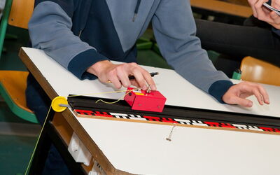 Nahaufnahme eines Physikexperiments eines Schülers.