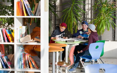 Eine Gruppe von Schülern sitzt an einem Tisch und arbeitet gemeinsam.