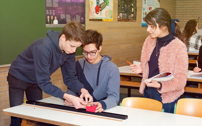 SchülerInnen arbeiten zusammen an einem Projekt und machen sich Notizen dabei.