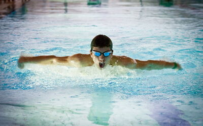 Ein Schüler trägt eine Schwimmbrille und ist konzentriert auf seinen nächsten Zug.