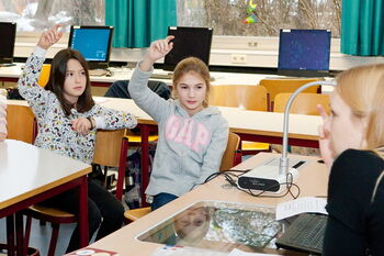 Eine Gruppe von SchülerInnen hebt die Hände, um Fragen zu stellen oder um Hilfe zu bitten.