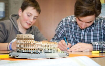 Zwei Schüler arbeiten gemeinsam und zeigen dabei viel Begeisterung und Teamarbeit.