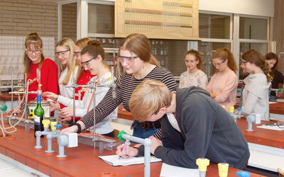 Eine Gruppe von SchülerInnen arbeitet gemeinsam in einem naturwissenschaftlichen Labor an einem Experiment.