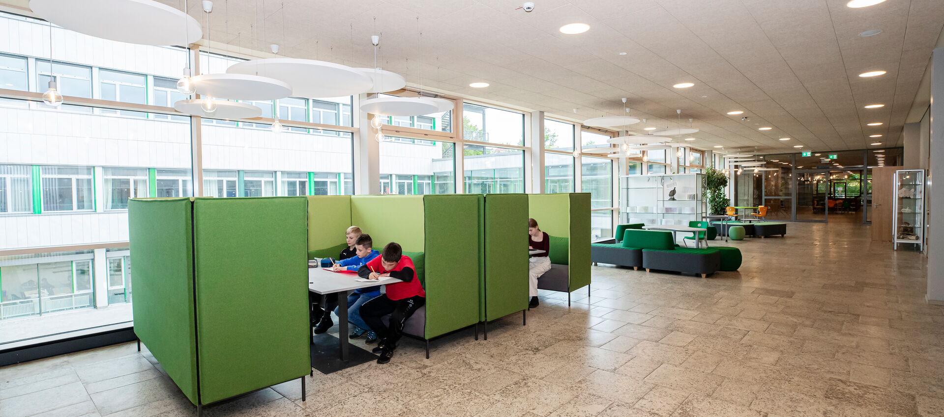 Schüler sitzen im Gang des Immanuel-Kant Gymnasiums Tuttlingen auf Sofas und lernen in ihrer Pause miteinander.