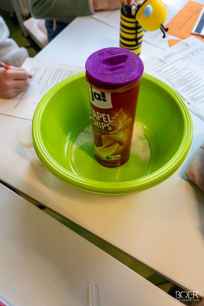 Eine Chipsdose in einer grünen Schüssel